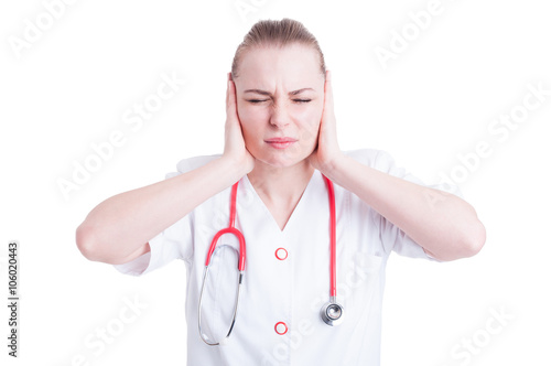 Frustrated young female doctor keeping eyes closed and covering