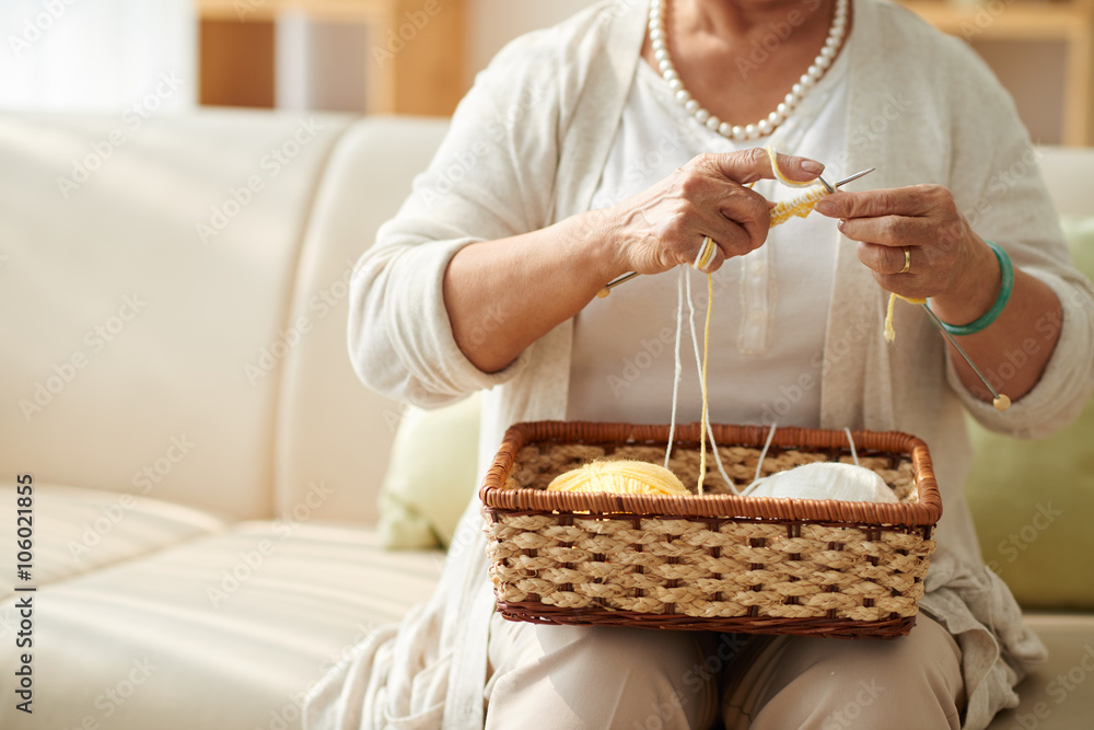 Cropped image of grandmother knitting at home