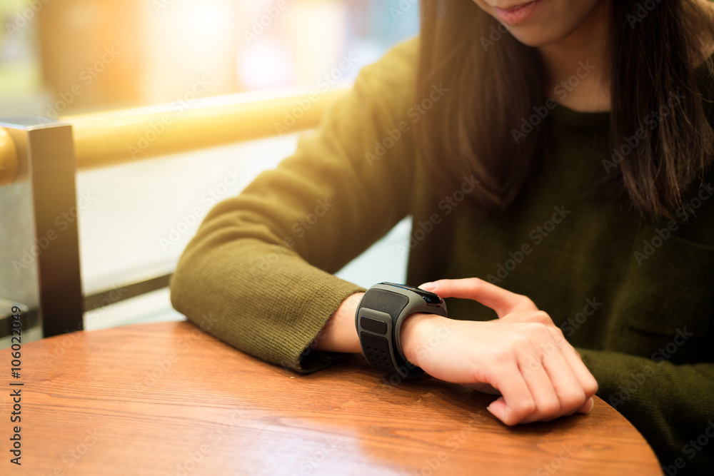 Woman touch on smart watch in cafe
