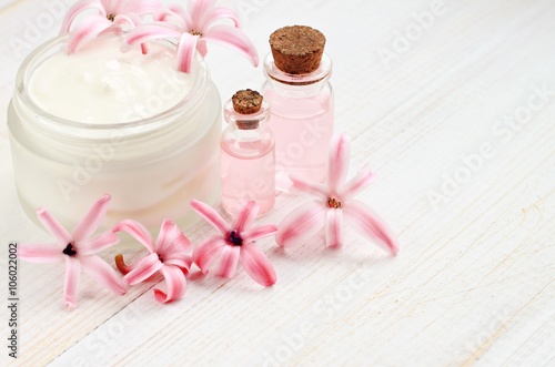 Cosmetic facial cream, bottles with aroma oil, hyacinth flowers. Natural beauty treatment. 
