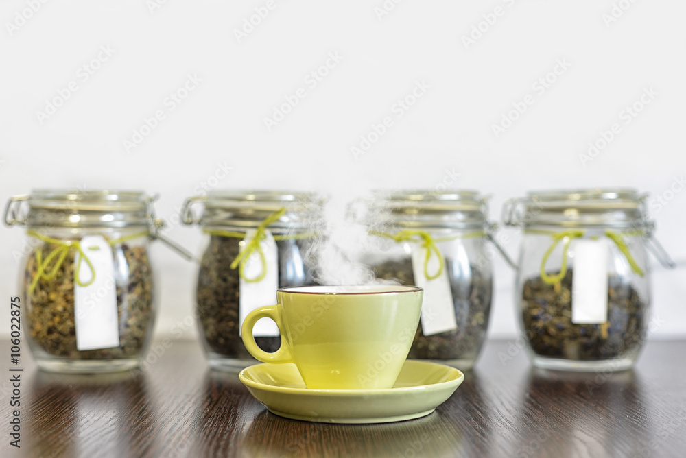 tea in glass jars and cup on wooden table with white background tea in glass jars and cup on wooden table with white background