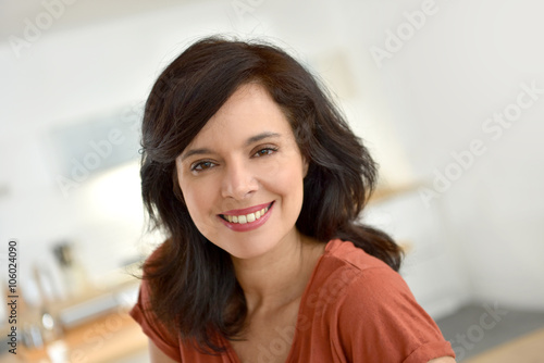 Portrait of smiling 40-year-old woman at home