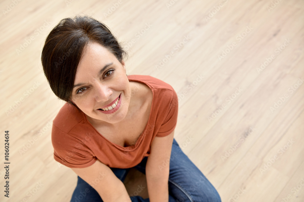 Portrait of beautiful woman sitting on wooden floor Portrait of beautiful woman sitting on wooden floor