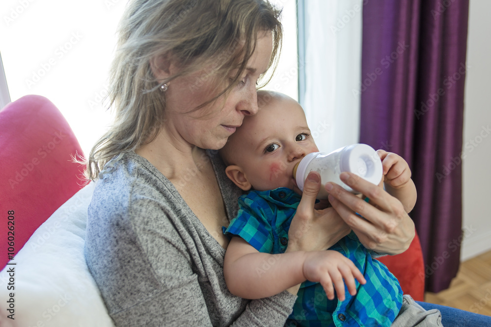 mother feeding her adorable son at home mother feeding her adorable son at home