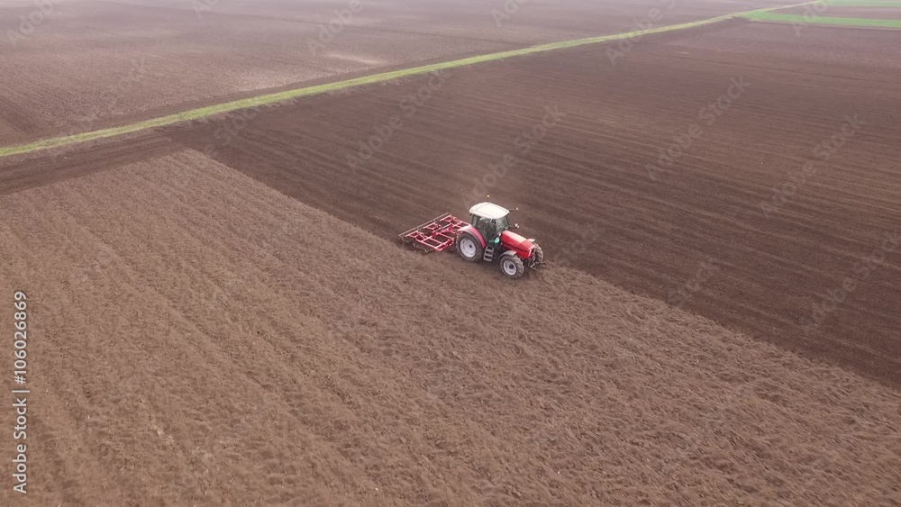 Farmer in tractor preparing land with seedbed cultivator Farmer in tractor preparing land with seedbed cultivator