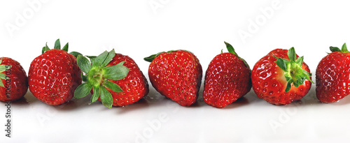 Ripe red strawberries laid in length on a white background. Panorama. Banner.
