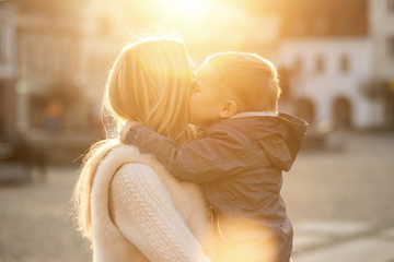 Happiness mother and son on the street at sunny day.