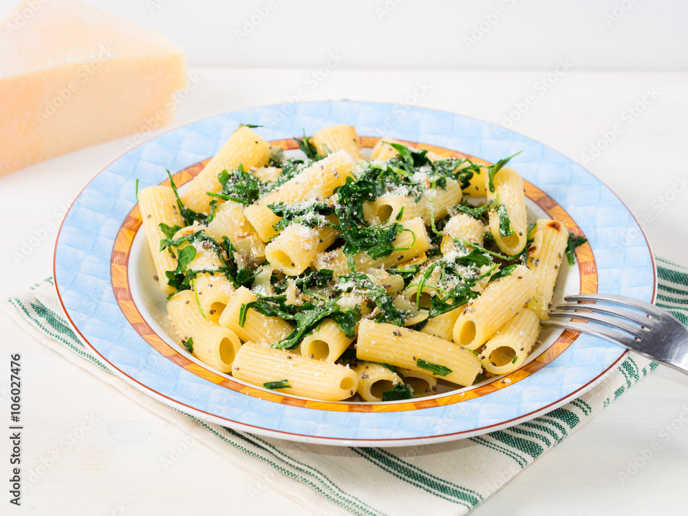 Closeup of rigatoni pasta with onion, arugula and chia seeds Closeup of rigatoni pasta with onion, arugula and chia seeds