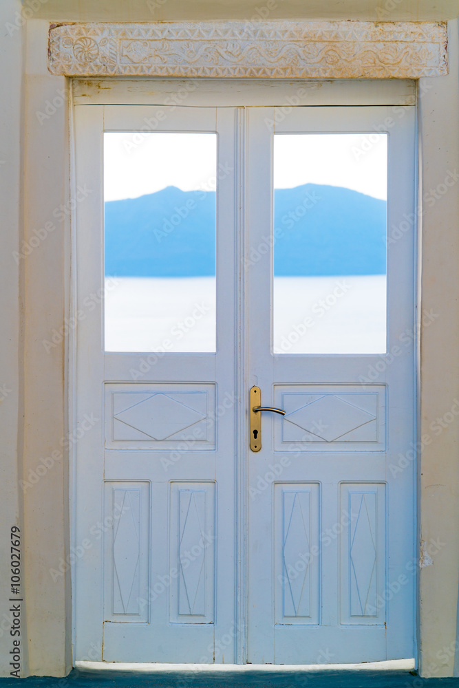Beautiful white wooden door above aegean sea in Oia, Santorini, Cyclades, Greece Beautiful white wooden door above aegean sea in Oia, Santorini, Cyclades, Greece