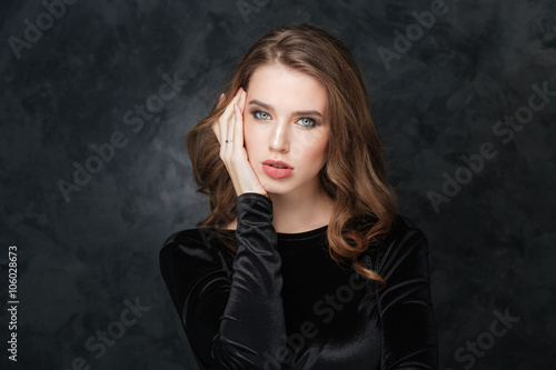 Beautiful young woman touching her face by hand