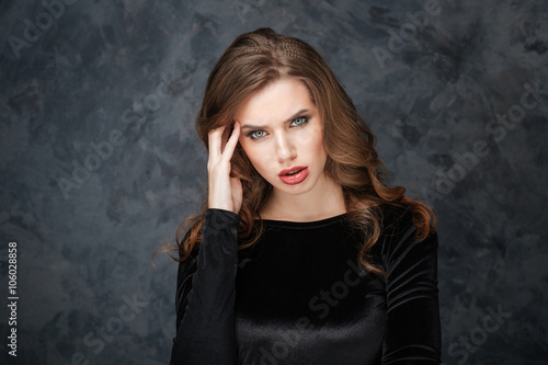 Upset pretty young woman having headache