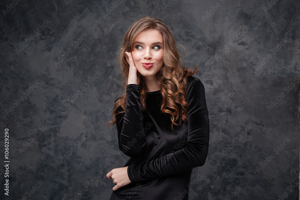 Amusing woman with long curly hair making funny duck face Amusing woman with long curly hair making funny duck face
