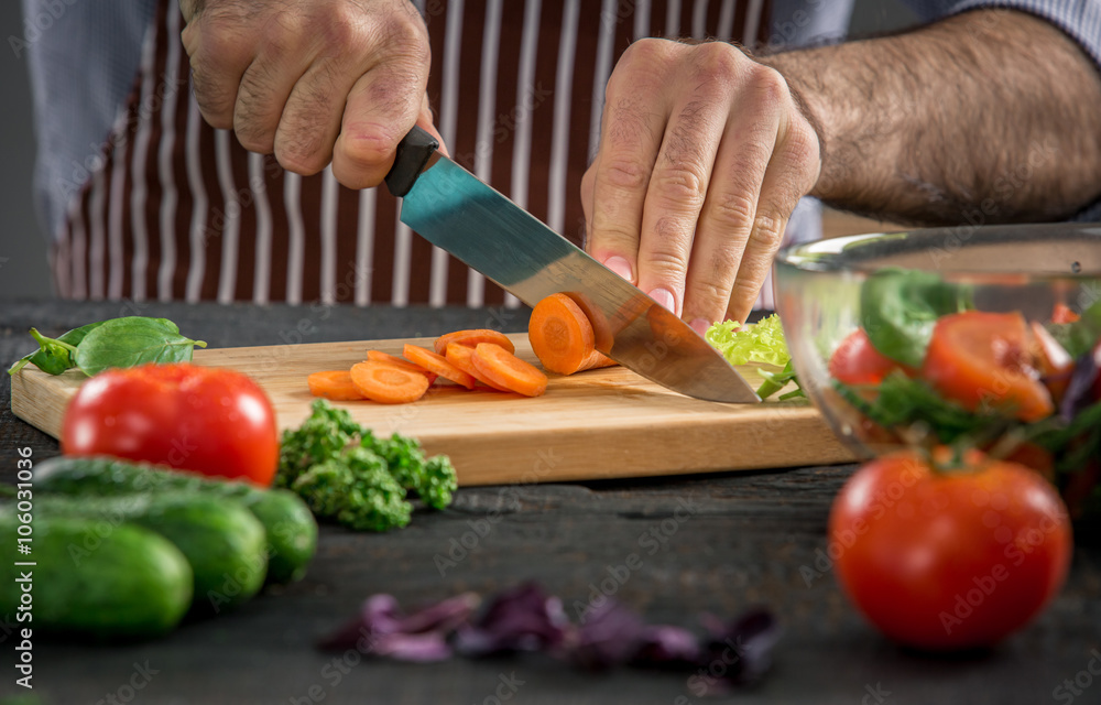 Male hands cutting vegetables for salad Male hands cutting vegetables for salad