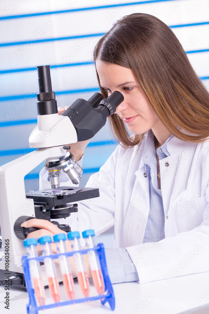 Young technician look at science microscope Young technician look at science microscope