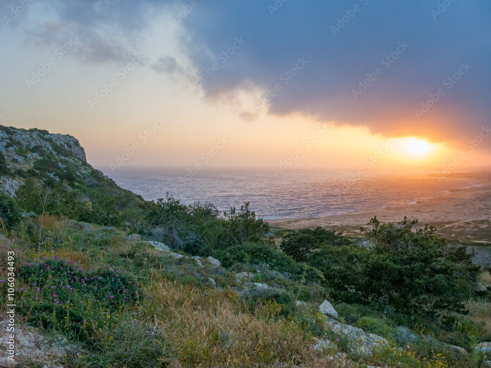 Dramatic sunset with storm cloudscape over Mediterranean Sea and coastline. Cape Greko, Cyprus.
