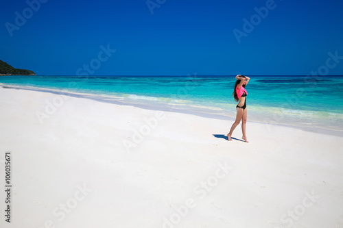 Enjoying life. Healthy woman walking on exotic sea. Fit brunette