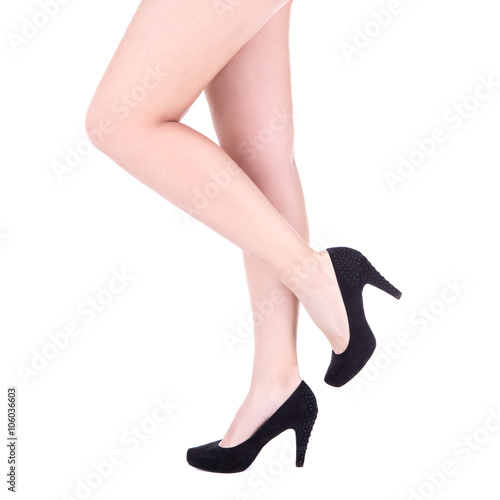 slim female legs in black shoes on heels isolated over white