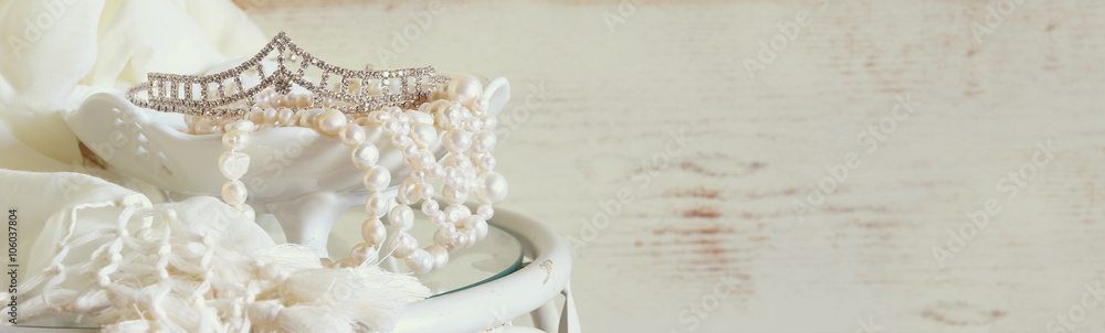 website banner background of white pearls necklace and diamond tiara on vintage table. toned image. selective focus
 - obrazy, fototapety, plakaty 