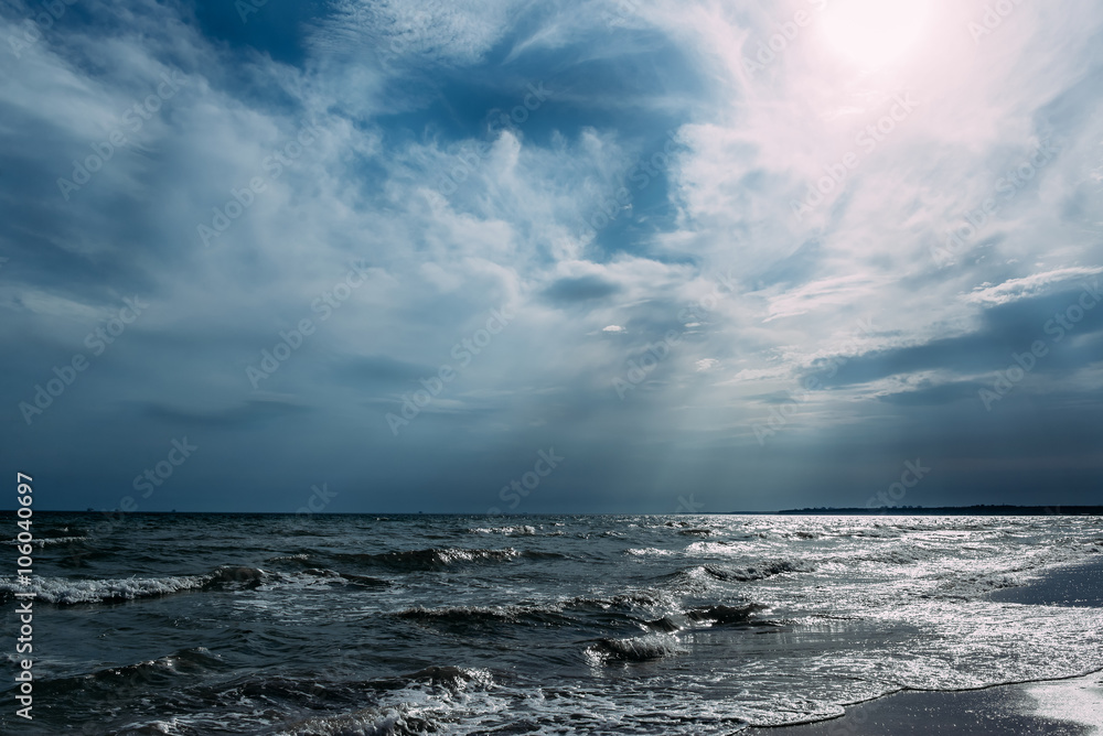 Blue sea with waves and clouds in the sky