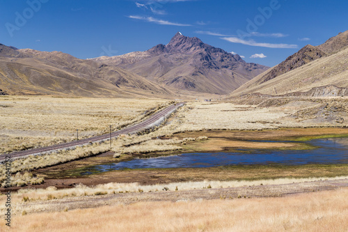 View of Andes mountains, small lake and railroad in Peru