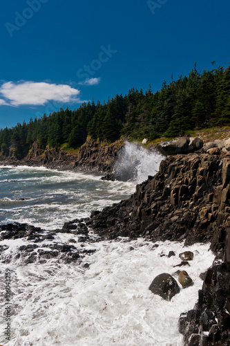 Waves crashing the basalt cliff.