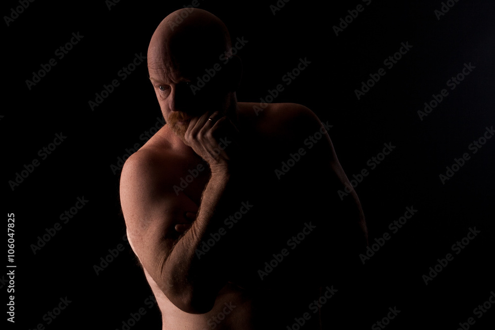 Topless bald man pondering life.