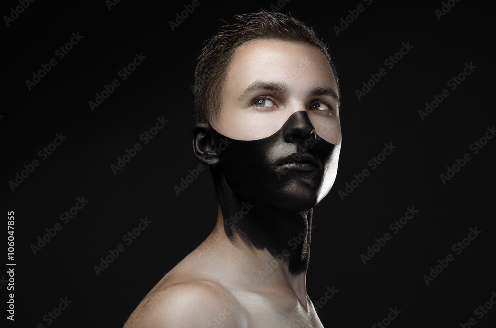 Handsome young guy with make-up with black mask on her face isolated on a  dark background in the studio Stock Photo | Adobe Stock