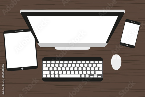 Workplace at a wooden table. Monitor, keyboard, computer mouse, tablet and smartphone