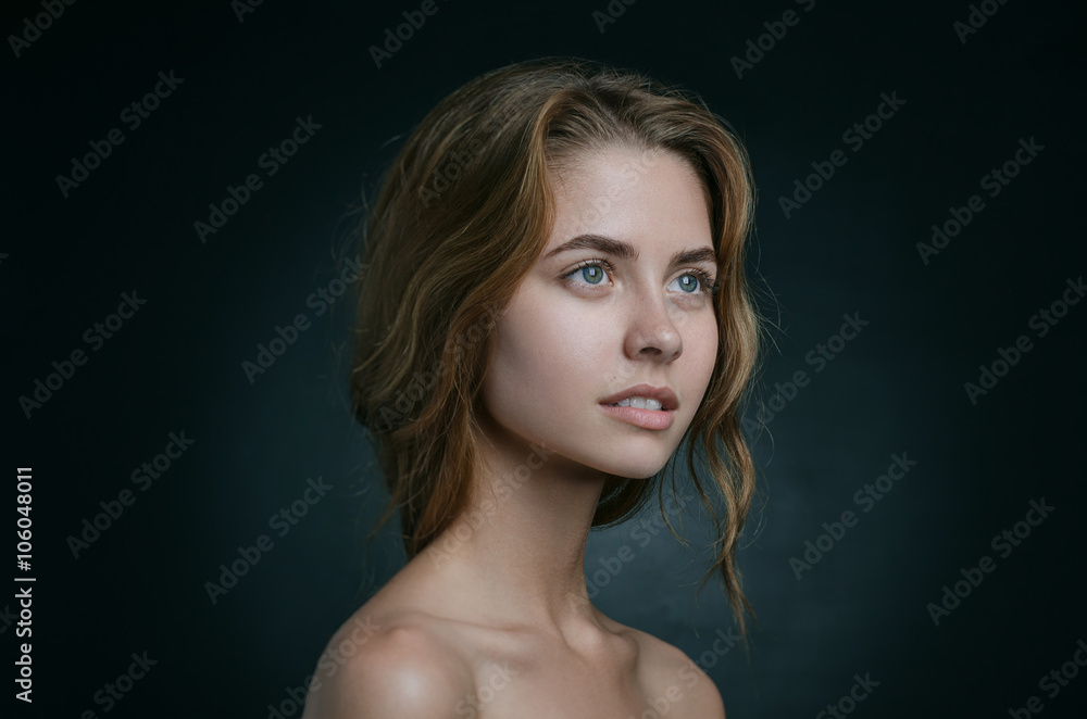 Dramatic portrait of a girl theme: portrait of a beautiful girl with flying hair in the wind against a background in studio Dramatic portrait of a girl theme: portrait of a beautiful girl with flying hair in the wind against a background in studio