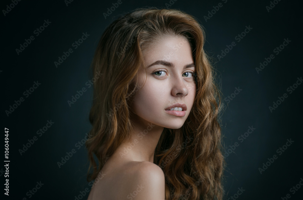 Dramatic portrait of a girl theme: portrait of a beautiful girl with flying hair in the wind against a background in studio Dramatic portrait of a girl theme: portrait of a beautiful girl with flying hair in the wind against a background in studio