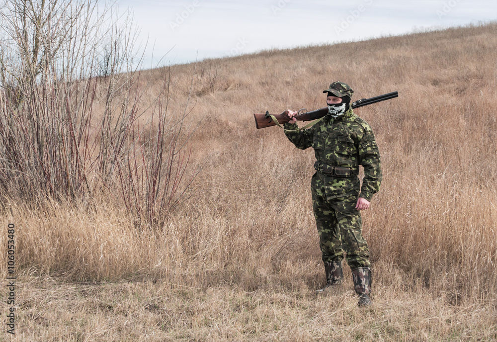 Hunter during a recreation, rifle on shoulder Hunter during a recreation, rifle on shoulder