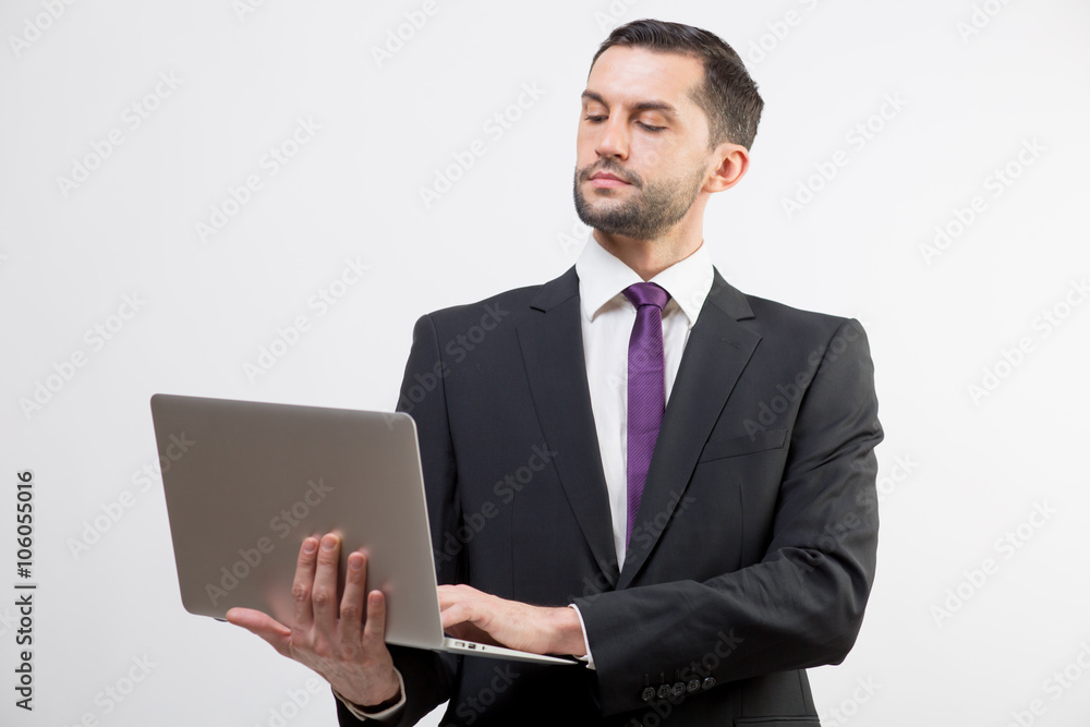 Young business man with a laptop in a studio Young business man with a laptop in a studio