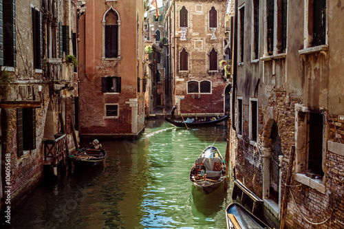 Horizontal oriented image of gondola passing on small canal among old historic houses in Venice, Italy © mshynkarchuk
