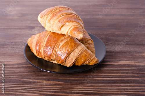 Fresh croissants on wooden background. Free space for your text. photo