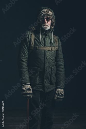 Retro old bearded mountaineer wearing hoody coat, backpack and s © ysbrandcosijn