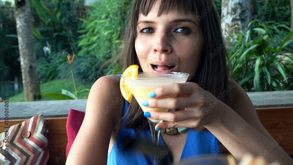 Happy woman talking and raising toast to camera in bar
Happy woman talking and raising toast to camera in bar