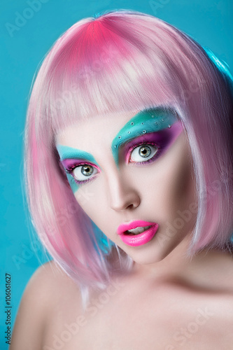 Closeup Beautiful face of puppet girl with face art in pink wig on serenity background