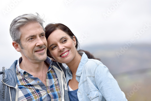 Cheerful middle-aged couple embracing outside