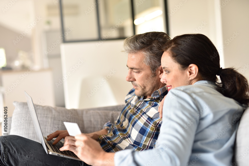 Couple in sofa websurfing and shopping on internet Couple in sofa websurfing and shopping on internet