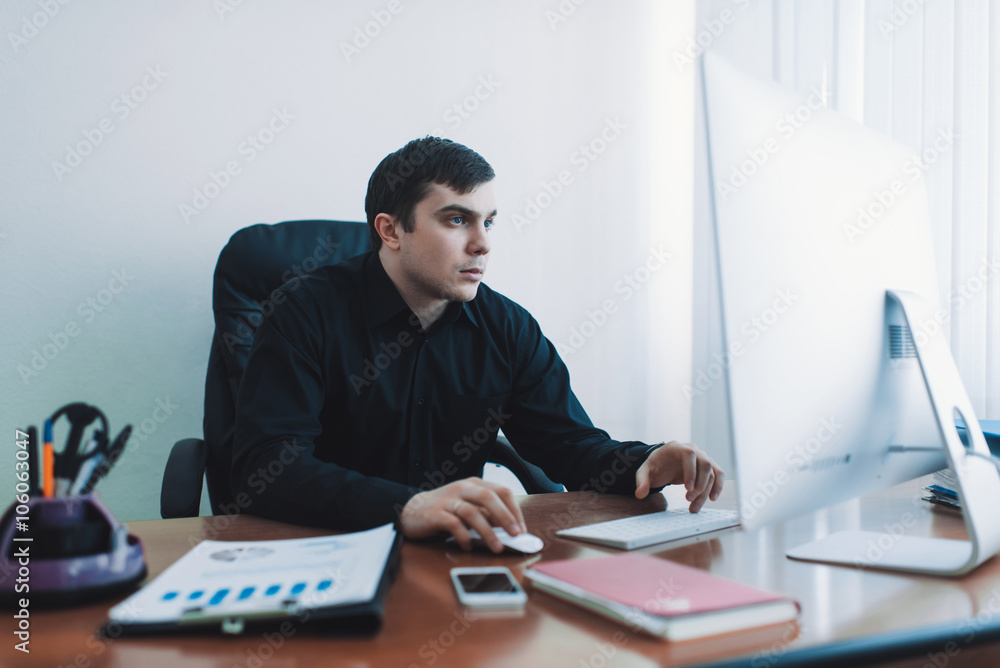 available for business men in black shirt working at desk computer available for business men in black shirt working at desk computer