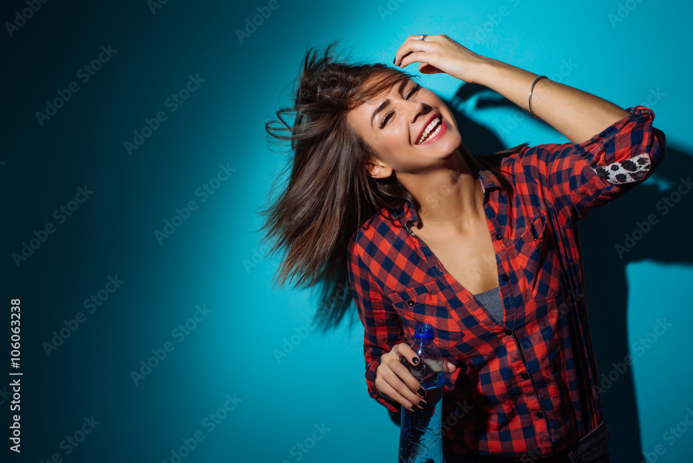 sexy beautiful girl with a bottle of drinking water in a red plaid shirt sexy beautiful girl with a bottle of drinking water in a red plaid shirt