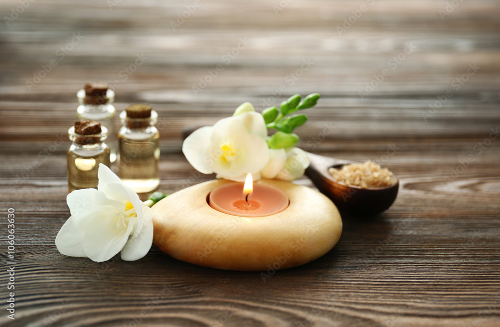 Spa set with sea salt, flowers and candles on wooden background