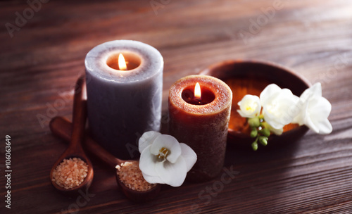 Spa composition with alight candles on wooden background