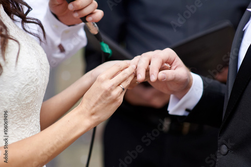 Принти на полотні bride wears a wedding ring on finger of groom