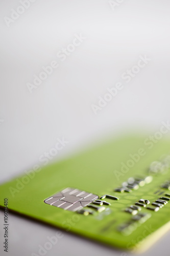 Chipped credit card. Shallow depth of field to highlight security chip element. White background.