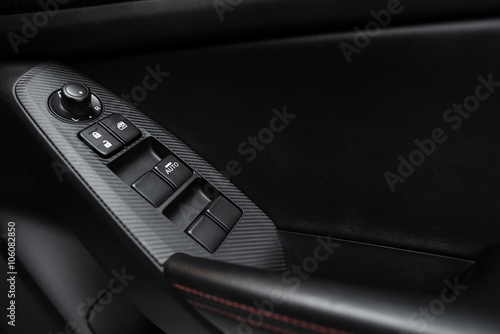 Car interior details of door handle with windows controls and adjustments. Car window controls and details © structuresxx