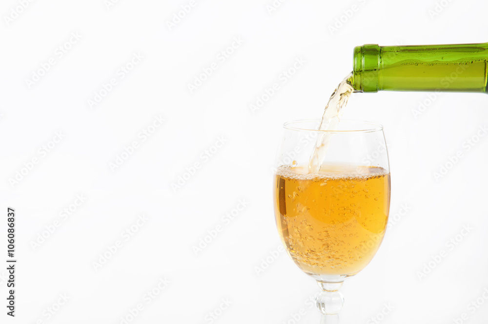 Pouring white wine from bottle into the wineglass