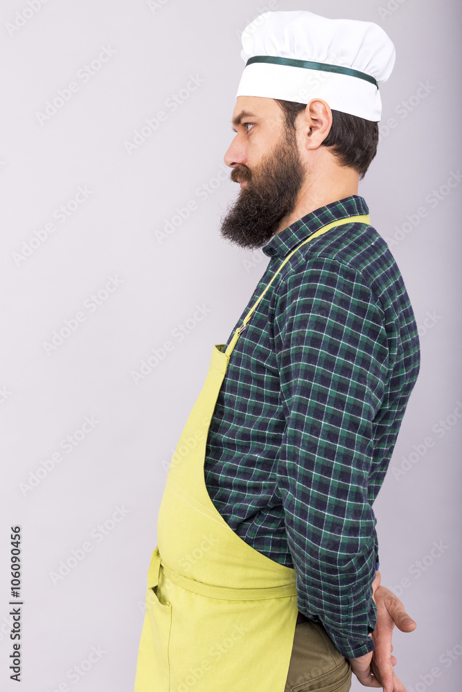 Studio shot of a bearded man with apron and cook hat Studio shot of a bearded man with apron and cook hat