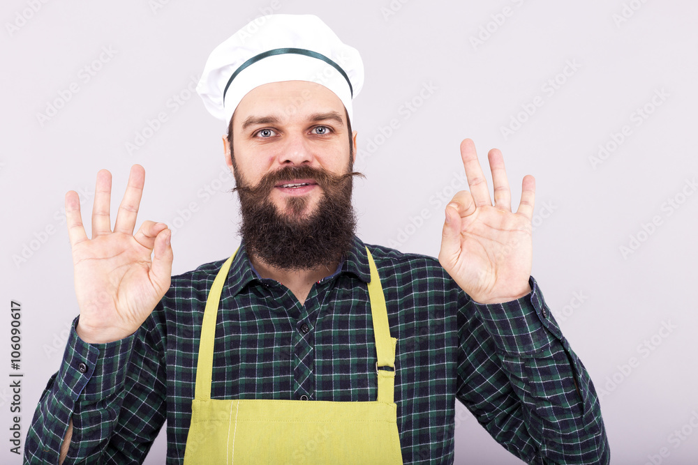 Studio shot of a bearded young man showing OK sign Studio shot of a bearded young man showing OK sign