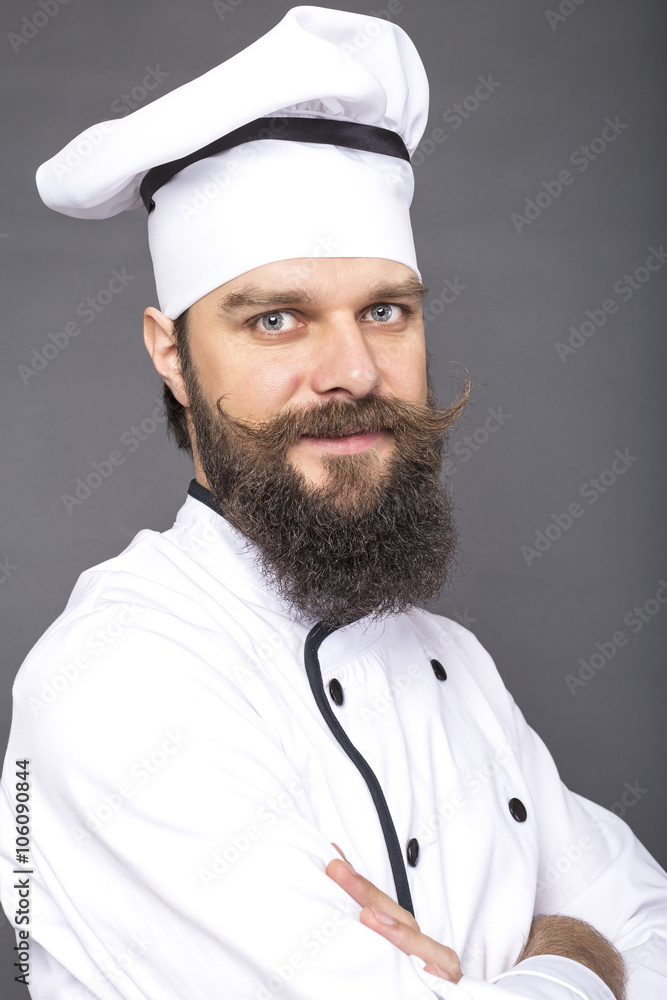 Portrait of a bearded young chef with arms folded